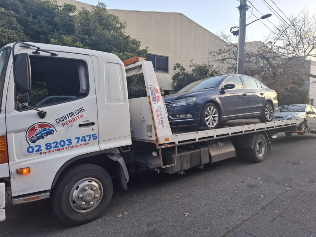 Dark blue Volkswagen Passat sedan loaded on the Cash For Cars Penrith tilt-tray truck