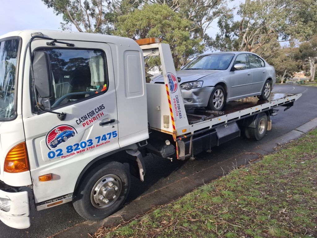 Silver Subaru Liberty sedan with front-end damage on the Cash For Cars Penrith tilt-tray truck
