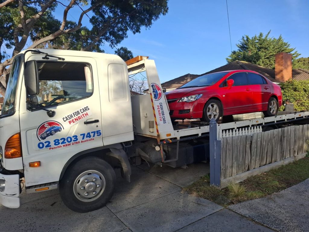 Red Honda Civic sedan with front damage on the Cash For Cars Penrith tilt-tray truck
