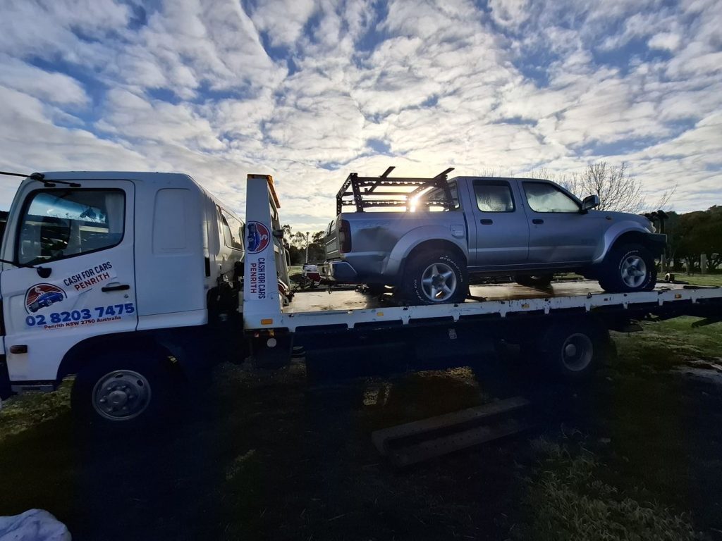 Silver dual-cab ute with a ladder rack on the Cash For Cars Penrith tilt-tray truck