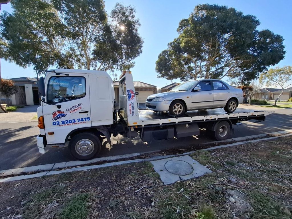 Silver Mazda sedan loaded on the Cash For Cars Penrith tilt-tray truck