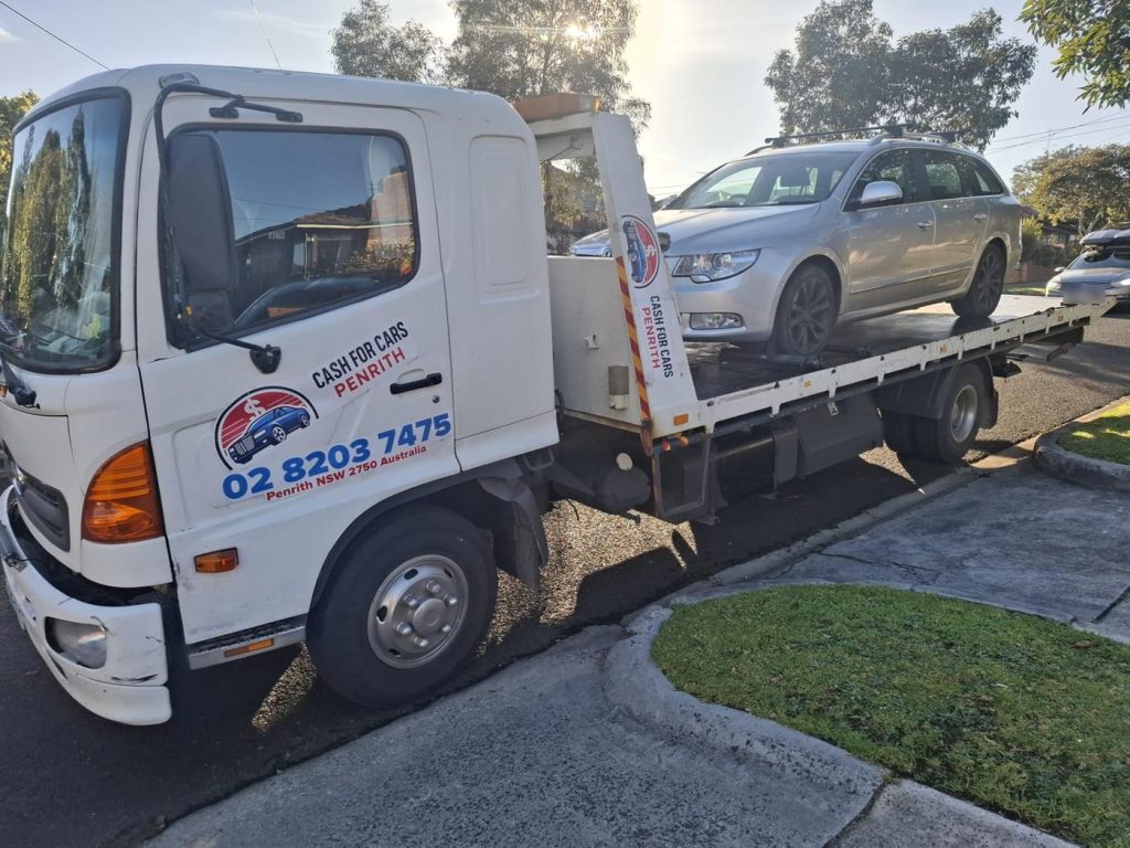 Silver Skoda Superb wagon loaded on the Cash For Cars Penrith tilt-tray truck