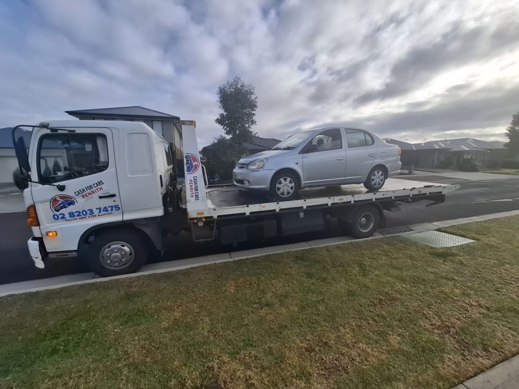 Silver Toyota Echo sedan on the Cash For Cars Penrith tilt-tray truck