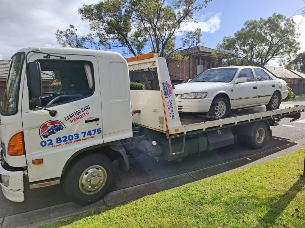 Older white Toyota Camry sedan on the Cash For Cars Penrith tilt-tray truck
